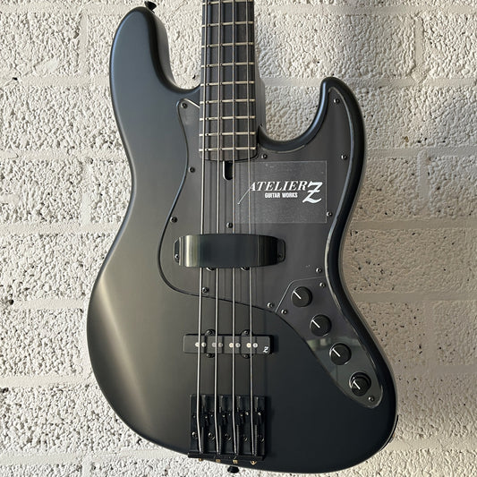Atelier Z M#245 Custom 4-string bass in Matt Black with matching headstock and black hardware body closeup